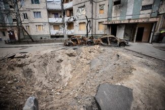 uszkodzony budynek i spalone samochody