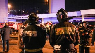 The photo shows firefighters in front of a burning building