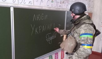 Photo shows a soldier writing "I love Ukraine" on a blackboard 