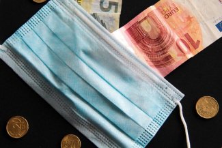 Zdjęcie przedstawia maseczkę i banknoty euro
