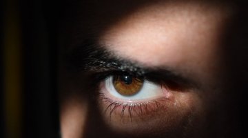 Zdjęcie przedstawia twarz osoby stojącej w cieniu