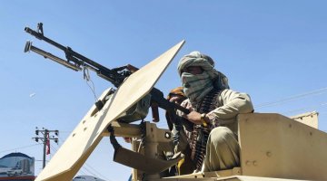 Na zdjęciu znajduje się talib z karabinem maszynowym